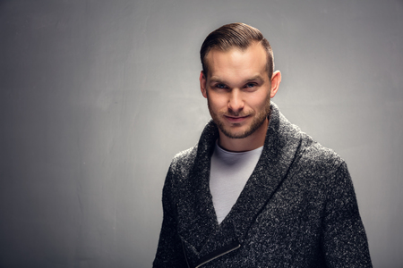 Young handsome brunet man looking confidently into the camera. Studio portraitの写真素材