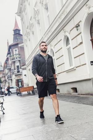 Young man walking on the street of a city. Millenial lifestyle.の写真素材