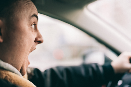Young man driving a car and screaming.の写真素材