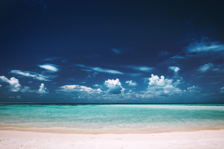 Sandy beach, clear see-through sea and blue sky. Tropical landscape. Seashore view, Maldives