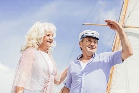 Older couple standing on a yacht, looking away.の写真素材