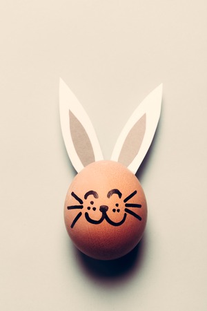 Easter egg with ears and whiskers, looking like a bunny. Homemade decoration.の写真素材