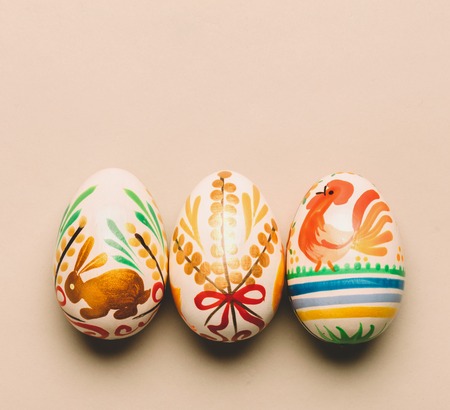 Three handmade Easter eggs on creamy background. Folk traditions. Slavic holiday.の写真素材
