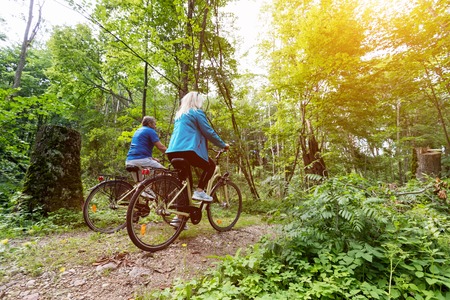 Senior couple enjoying their ride in the forest. Cycling. Fitness lifestyleの写真素材