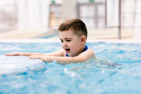 Young boy in a hot tub having fun, relaxing. Water park. Leisure activities.