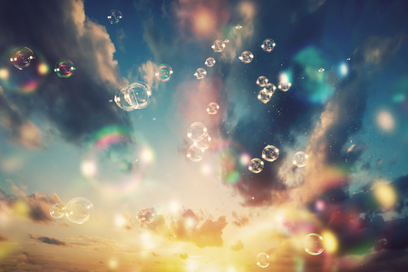 Floating soap bubbles and a sunset sky background. Dreamy backdrop.の写真素材