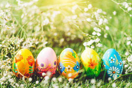 Five Easter eggs on green grass. Colorful traditional decoration, spring holiday.