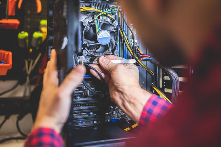Man fixing PC in professional workshop. IT service and engineering. Electronical device.