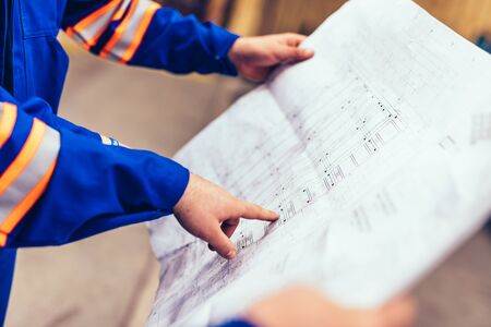Engineers showing construction plans in a factory. Heavy industryの写真素材