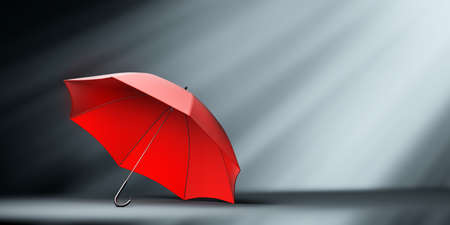 Red umbrella in spotlight. Protection, insurance and security concepts.の写真素材
