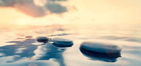 Mindfulness and meditation background. Zen rocks on water at sunset. 3D renderの写真素材
