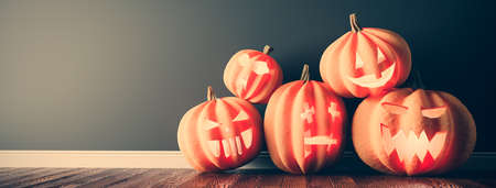 Halloween pumpkins on wooden floor at home. Jack-o'-lantern scary carved facesの写真素材