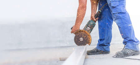 Worker grinding a steel profile, industrial work. Construction site, metalworkの写真素材