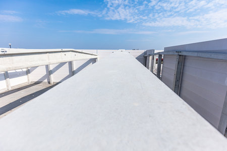Roof construction on warehouse building site. Building a new industrial hall or storehouseの写真素材