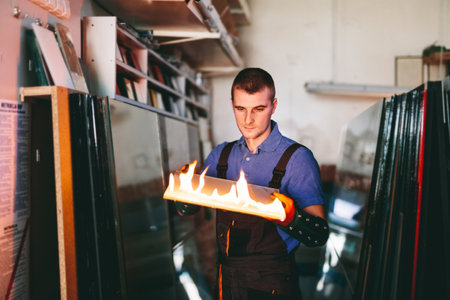 Glazier worker cutting glass with fire in a workshop. Industryの写真素材