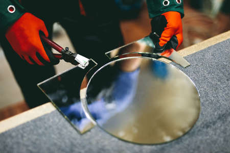Glazier worker cutting glass with compass glass cutter in a workshop. Industryの写真素材
