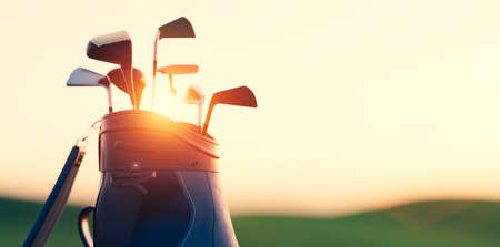 Golf clubs in bag at golf course resort at sunsetの写真素材
