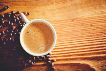 Coffee cup and beans on wooden table. Top viewの写真素材