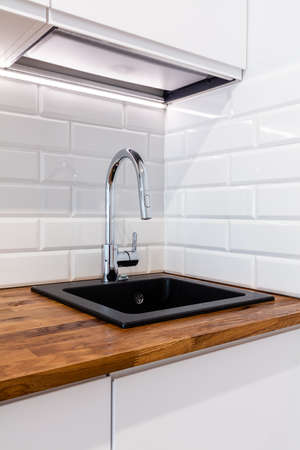 New clean kitchen with wooden table top. Fitted kitchenetteの写真素材