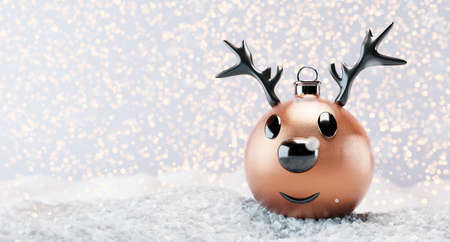 Reindeer Christmas ball ornament on snow, glitter lights background. 3D illustrationの写真素材