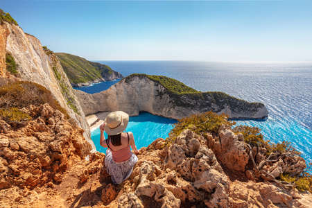 Woman tourist in Zakynthos, Greece admiring the Navagio shipwreck beachの写真素材