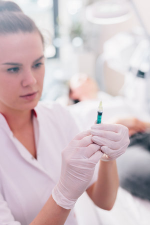 Aesthetic medicine doctor preparing syringe for injection in beauty salonの写真素材