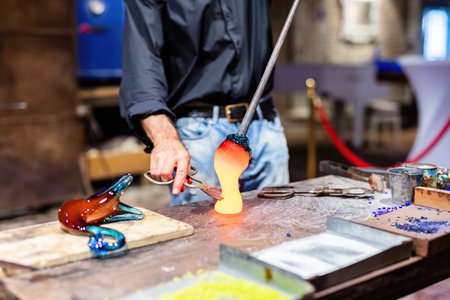 Glass blower at work in workshop in Murano, Italy, making handmade glasswareの写真素材