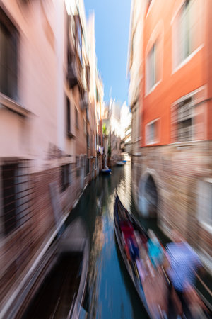 Gondolier rowing gondola on scenic canal in Venice, Italy. motion blurの写真素材