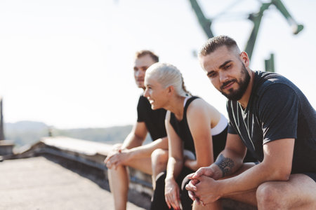 Friends resting after workout in clothed neighborhood. active lifestyleの写真素材