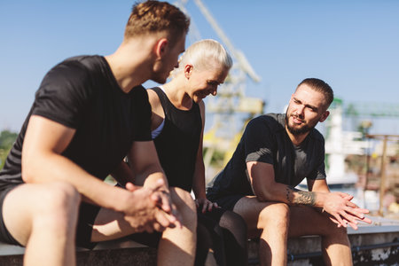 Friends resting after workout in clothed neighborhood. active lifestyleの写真素材