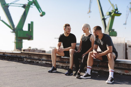 Friends resting after workout in clothed neighborhood. active lifestyleの写真素材