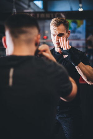 Man on boxing training with instructor on a gym