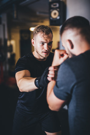Man on boxing training with instructor on a gymの写真素材