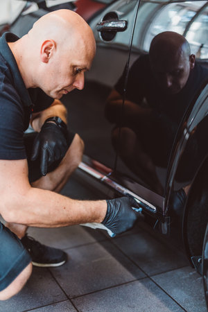 Service man washing car before detailing in workshop. Professional workの写真素材