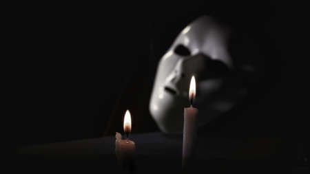 Black mask with candles on a black background. The concept of Halloween.の写真素材