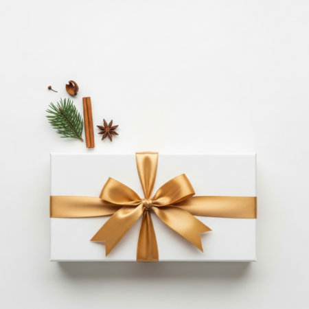Elegant gift box with golden ribbon and seasonal decorationsの素材