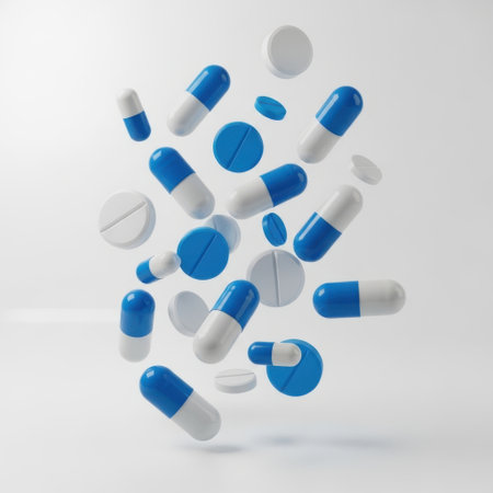 An image showcasing a variety of pills and capsules floating in midair against a plain white background. The pills are predominantly blue and white, with some being round and others oval. The arrangement creates a dynamic and visually appealing composition.の素材