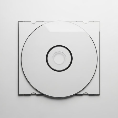 A blank CD is shown in a clear plastic case. The CD is positioned in the center of the case, which has a transparent cover and a black spine. The background is plain white, providing a stark contrast to the black and clear elements of the CD and case.の素材