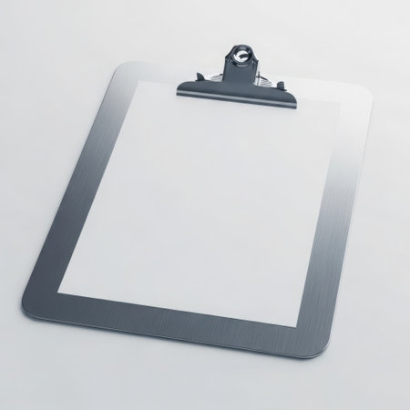 The image depicts a blank clipboard with a single sheet of white paper secured by a black clip. The clipboard itself has a dark gray frame, and the paper is pristine with no writing or markings. The background is a plain light gray surface, providing a neutral backdrop that highlights the clipboard and paper.の素材