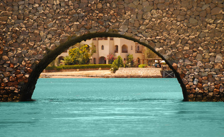 Beautiful stone bridge with arch, canal, coastlineの写真素材