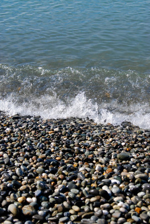 Gray dark stones of different shapes and colors on the beach
