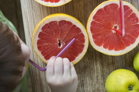 Beautiful view of fresh grapefruit on the table and babyの写真素材