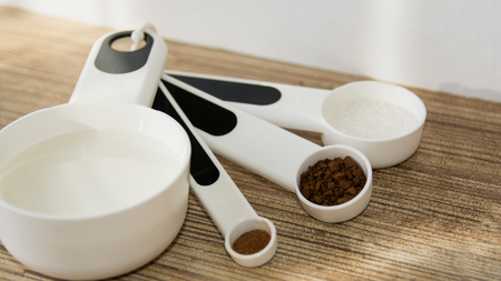 Glass cup of coffee, spoon, table, sugarの写真素材