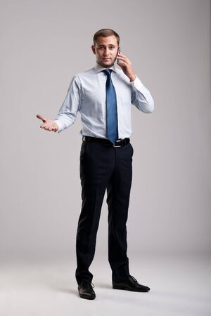 Young and successful businessman holding a smartphoneの写真素材