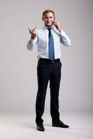 Young and successful businessman holding a smartphoneの写真素材