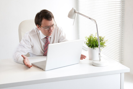 Young and funny businessman staring at his laptopの写真素材