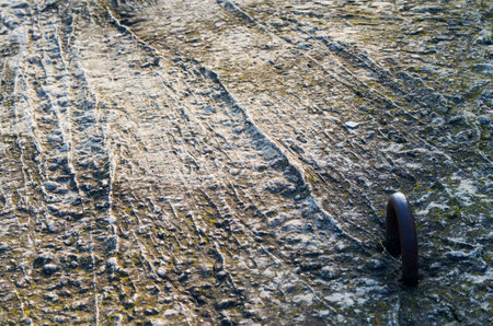 Shows a portion of the surface of the concrete slab with a metal loop to lift it with side lighting.の写真素材