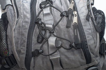 In the image, a fragment of a full backpack with fastening elements and zipper locks, close-up.の写真素材