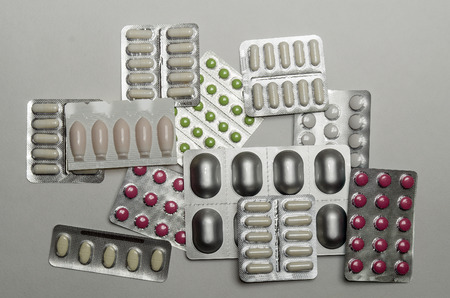 Medicines for various purposes in blisters scattered on the plane, close-up.の写真素材