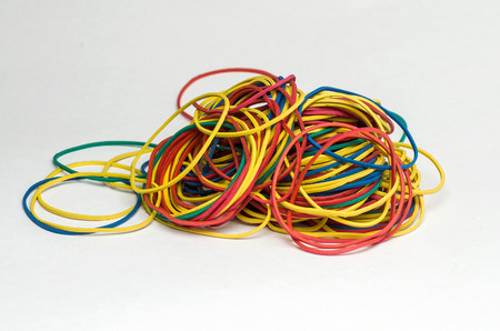 A pile of multi-colored rubber bands stationery, ready to use, is disordered mass on a white plane, close-up.の写真素材